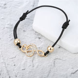 CZ Studded Treble Clef on Contrasting Black Rope Bracelet